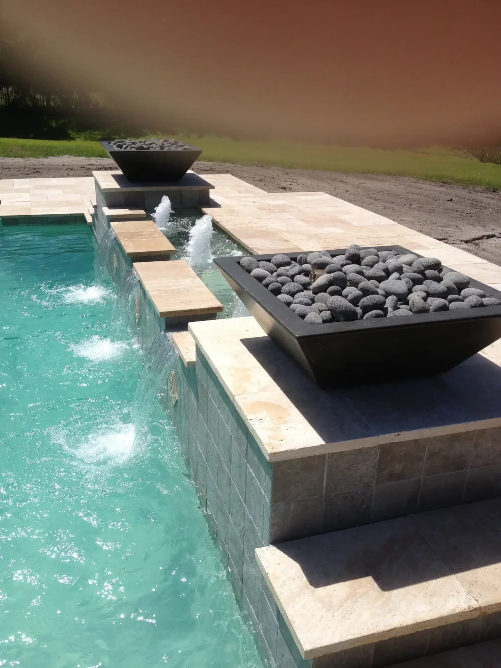 Close-up of fire bowls and water features for custom geometric pool