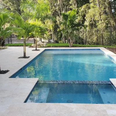 Custom built geometric pool with spa & planters on pool deck.