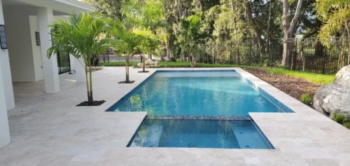 Custom built geometric pool with spa & planters on pool deck.