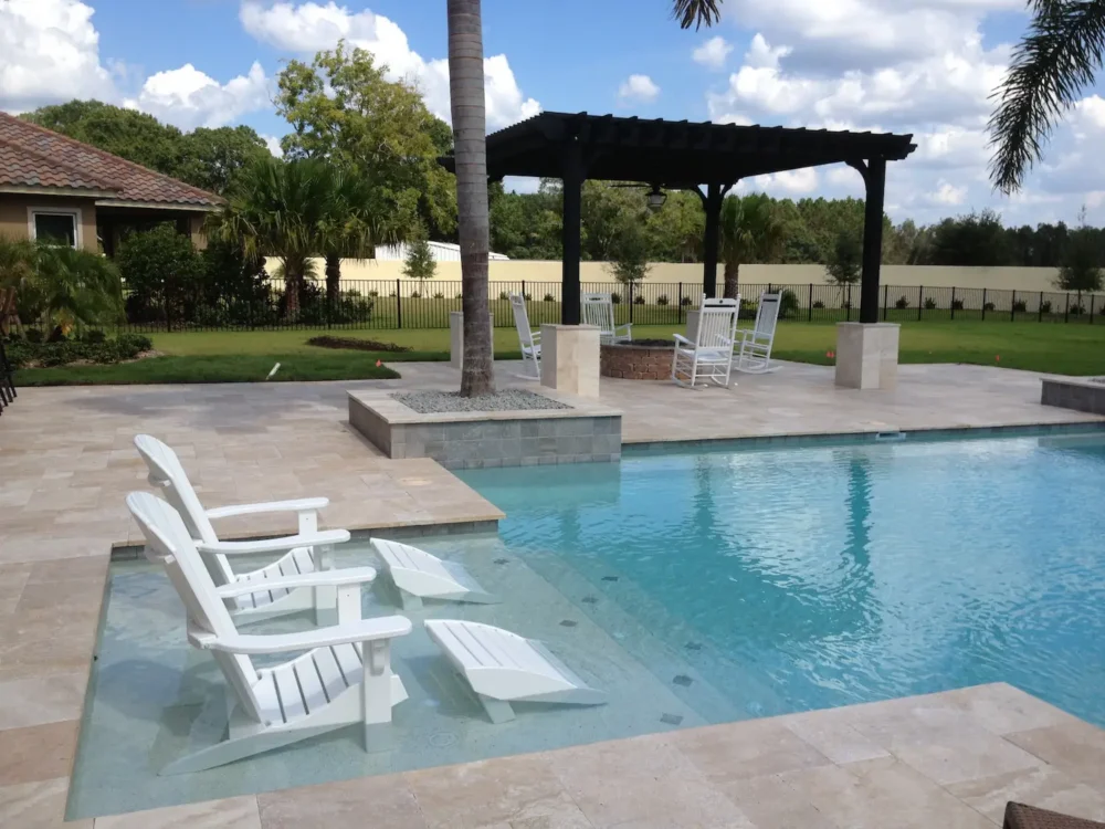 geometric pool with sun shelf, planters and pergola over a fire pit installed by a custom pool builder