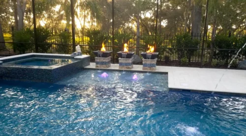 Custom geometric pool with spa, fire bowls, multiple water features, sun shelf, and LED lighting