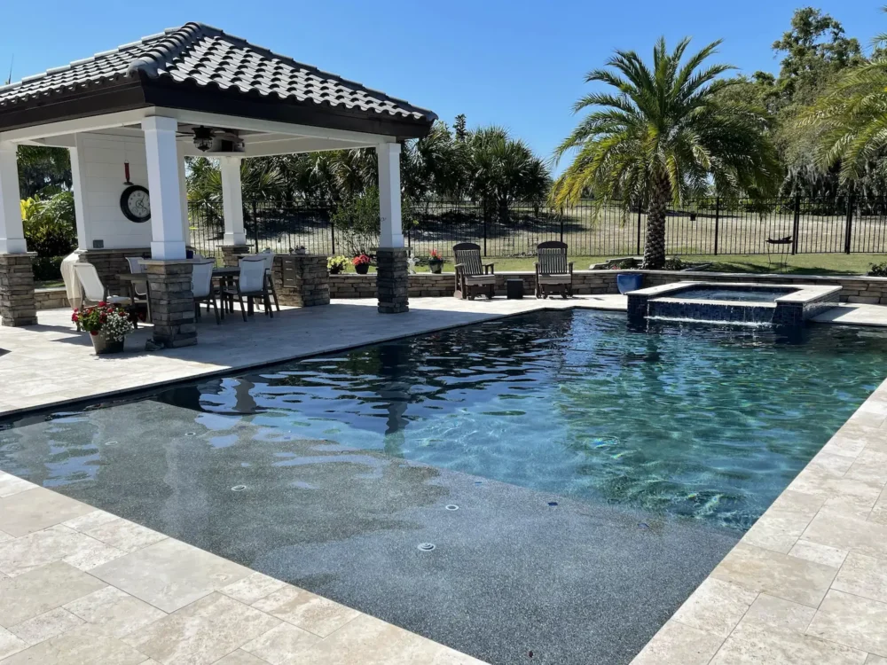Custom geometric pool with sun shelf, spillover spa, and patio cover