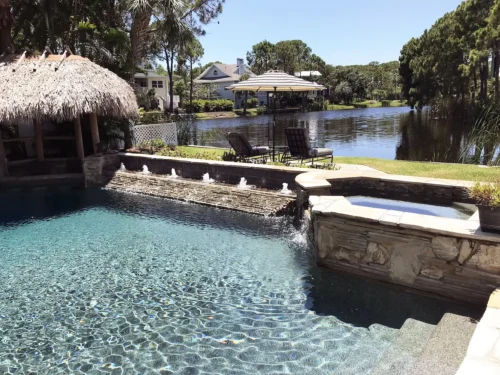 Custom pool with swim-up bar, spillover spa, and multi spout water bubblers