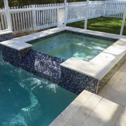 Custom spillover spa integrated into a geometric pool