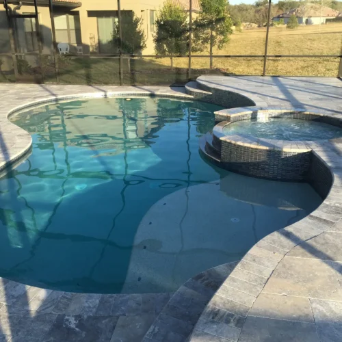 Freeform custom built pool with spillover spa and sun shelf