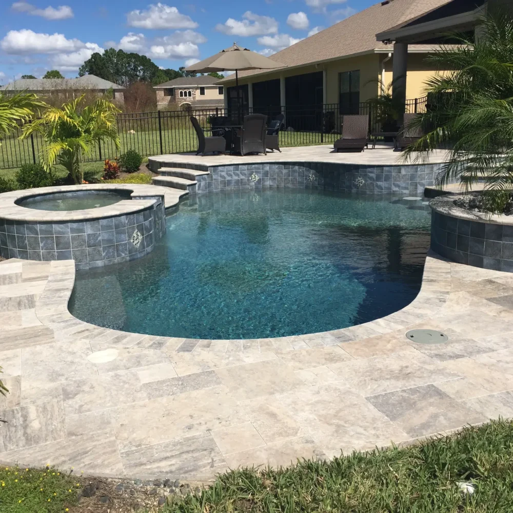 Freeform custom pool with raised spa with spill over water feature and planters