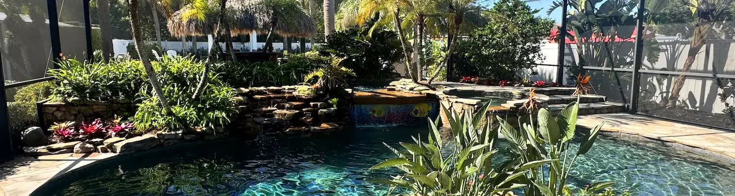 Freeform, lagoon style pool with spillover spa, waterfalls, and planters.