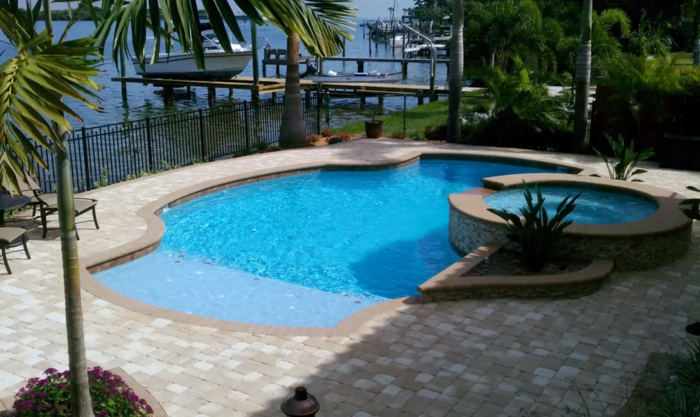 Geometric pool with spillover spa, sun shelf, & planters.
