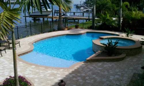 Geometric pool with spillover spa, sun shelf, & planters.