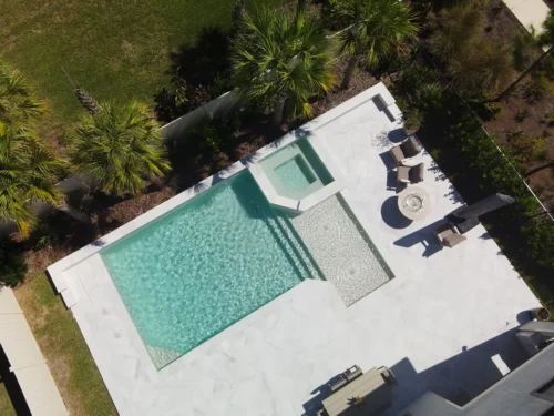 Geometric pool with sun shelf and raised, spillover spa.