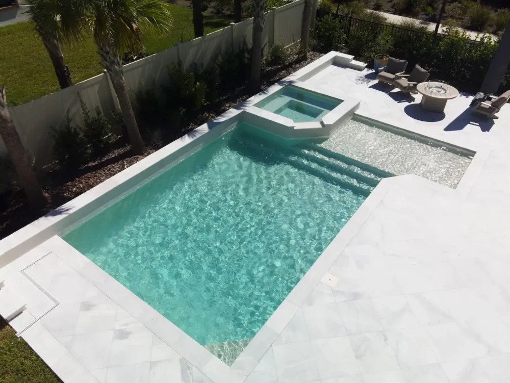 Geometric pool with sun shelf and raised, spillover spa.