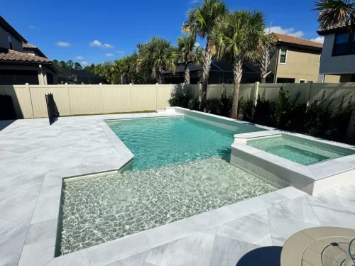 Geometric pool with sun shelf and raised, spillover spa.