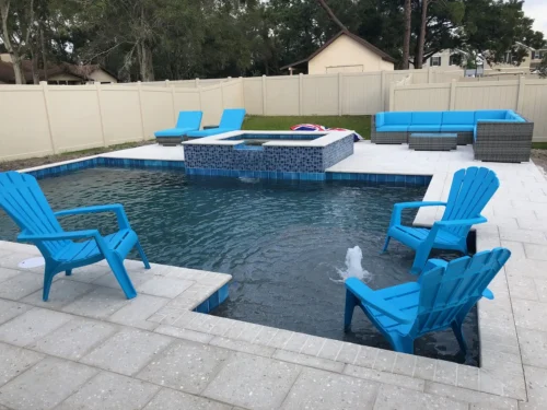 Geometric pool with water bubblers, sun shelf, & spillover spa.