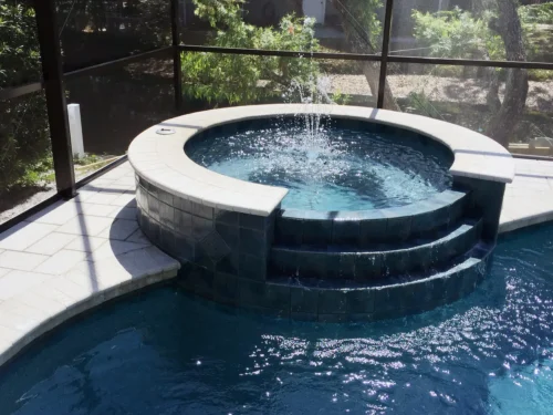 Custom spillover spa and bubbler integrated into a freeform pool.